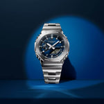 Casio G-Shock G-Steel GM-2110D-2BER kellon kuva sinisellä taustalla, metallinen ulkoasu ja tyylikäs muotoilu.