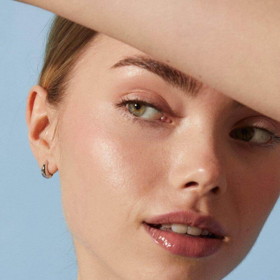 Sparv Dewdrop Kullatut Korvakorut 1730101 käytössä, lähellä kasvokuvaa nuoresta naisesta.