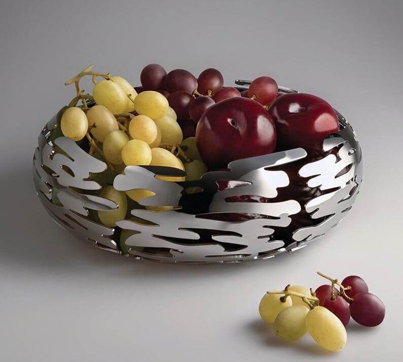 Alessi Barknest Hedelmäkulho BM02, kaunis muotoiltu hedelmäkulho, jossa on viinirypäleitä ja omenoita.