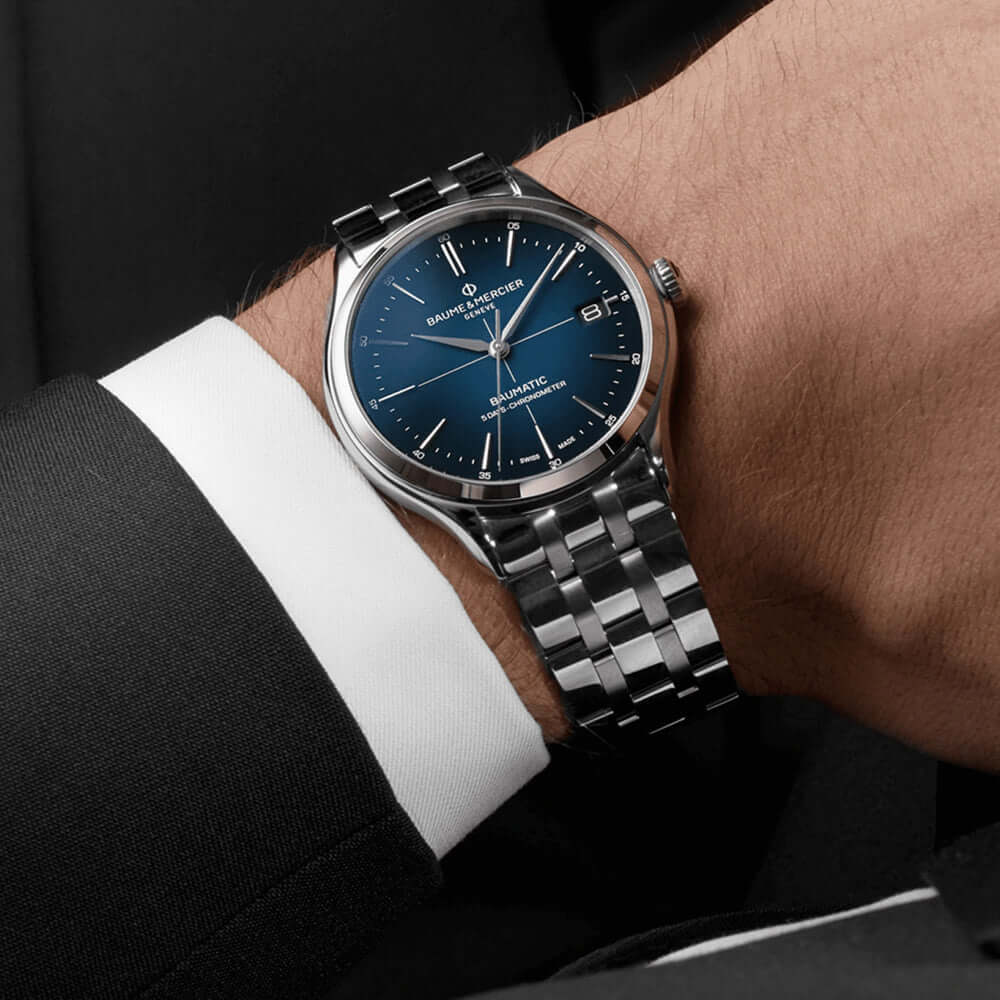 Baume & Mercier Clifton Baumatic 10468 -kello tyylikkäällä metallirannekkeella ja sinisellä kellotaululla.