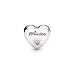 Pandora Sister's Love Charm Hela 791946PCZ sydämenmuotoinen koru, jossa teksti 'Sister' ja vaaleanpunainen zirkoni.